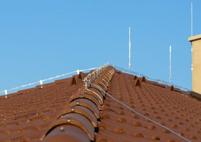 Tile roof with chimney and lightning protection system installed. Lightning rods. Close-up shot. Lightning conductor.